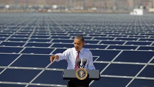 Obama giving a speech in front of solar panels