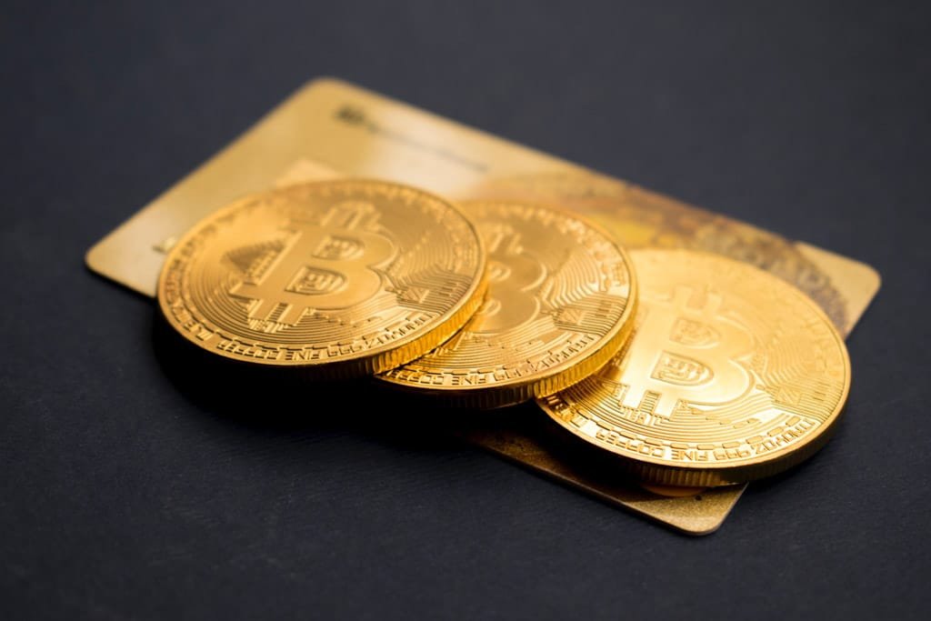 Gold bitcoin on top of gold bars