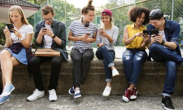 Bunch of millennial sitting and looking at phone