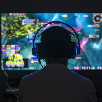 Gamer wearing headphone playing game in the dark
