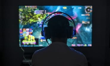 Gamer wearing headphone playing game in the dark
